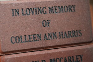 A brick that reads "In Loving Memory of Colleen Ann Harris