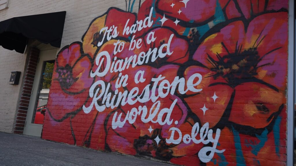 A mural that reads It's hard to be a diamond in a rhinestone world. -Dolly